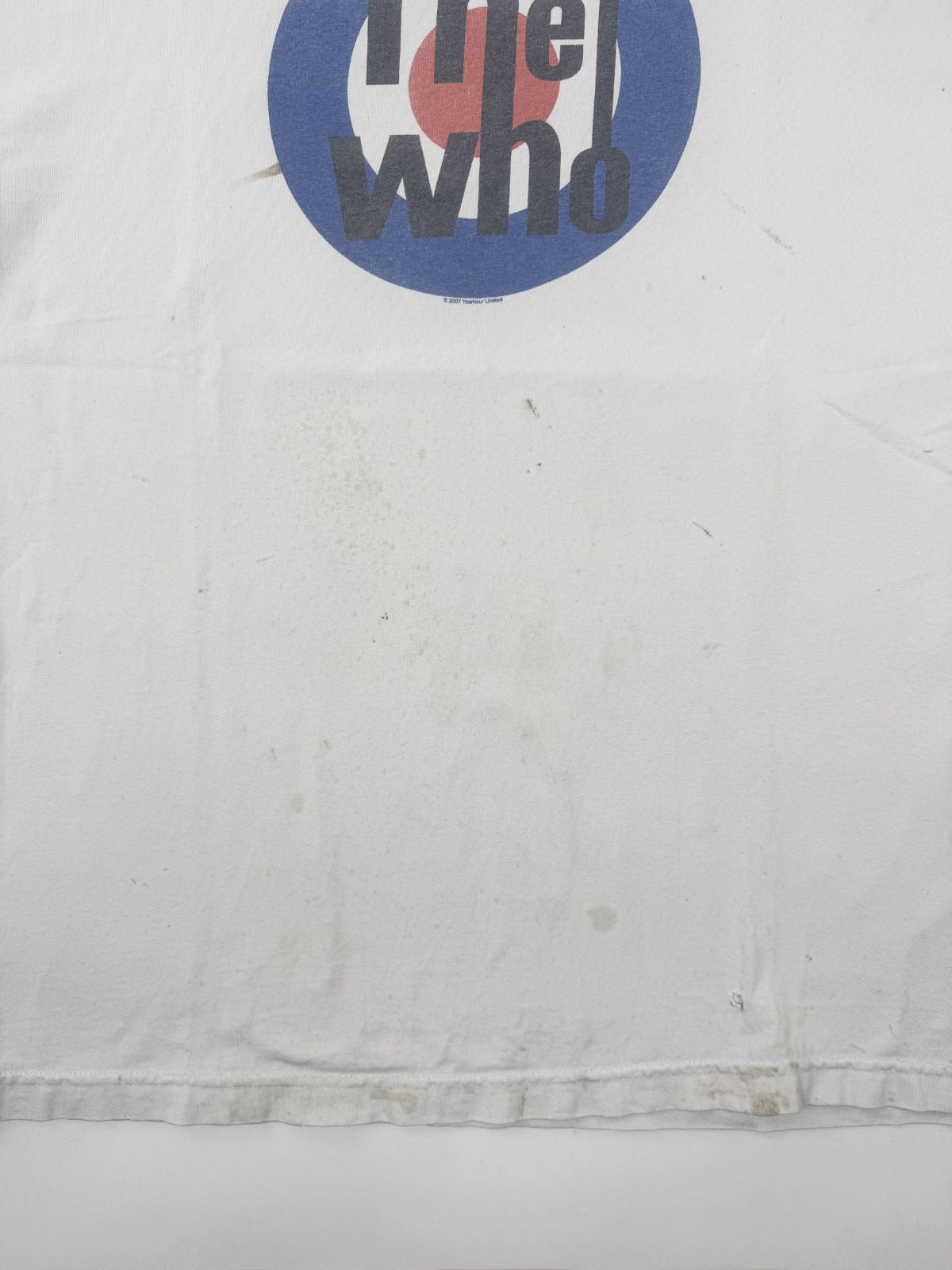 Großaufnahme der Vorderseite des weißen The Who Shirts; zeigt verstreute Vintage-Flecken und Verfärbungen unterhalb des Target-Logos auf dem Baumwollstoff.